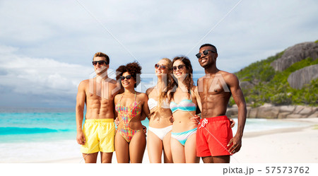 happy friends in swimwear hugging on summer beach happy friends in swimwear hugging on summer beach 57573762