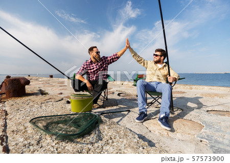 male friends with fishing rods making high five male friends with fishing rods making high five 57573900