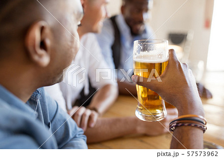 male friends drinking beer at bar or pub male friends drinking beer at bar or pub 57573962