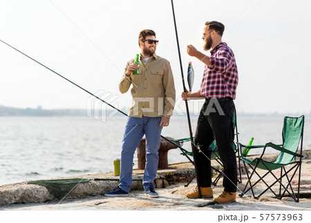 male friends with fishing rods and beer on pier male friends with fishing rods and beer on pier 57573963