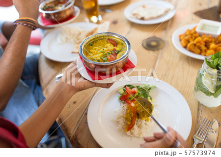 woman eating with friends at restaurant 57573974