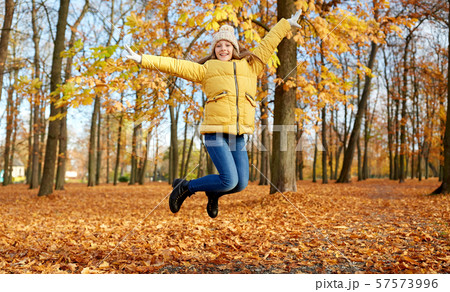 happy girl jumping at autumn park happy girl jumping at autumn park 57573996