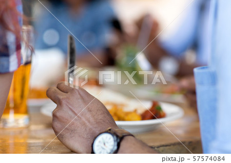 african man eating with friends at restaurant african man eating with friends at restaurant 57574084