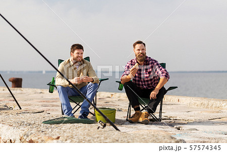 happy friends fishing and eating sandwiches happy friends fishing and eating sandwiches 57574345