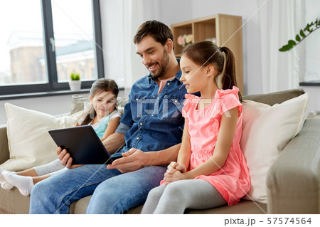 happy father and daughters with tablet pc at home happy father and daughters with tablet pc at home 57574564