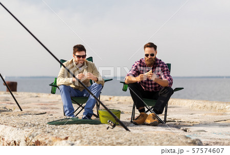 happy friends fishing and eating sandwiches 57574607