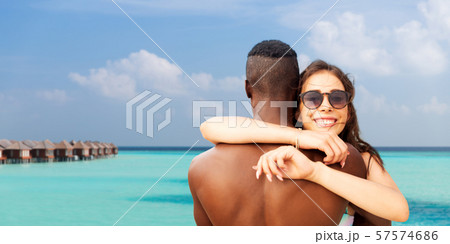 happy mixed race couple hugging on summer beach happy mixed race couple hugging on summer beach 57574686