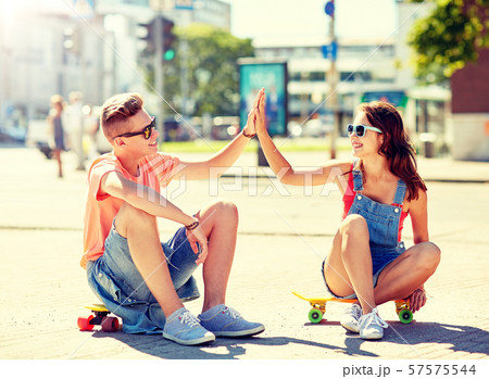 teenage couple with skateboards on city street 57575544