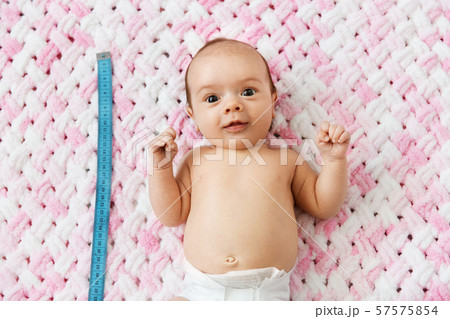 baby girl lying with measure tape on blanket baby girl lying with measure tape on blanket 57575854