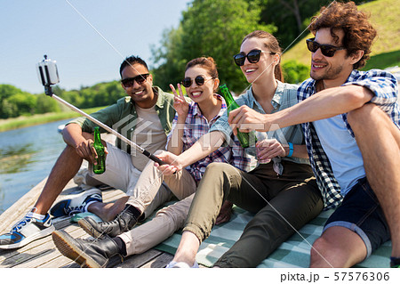 friends with drinks taking selfie on lake pier friends with drinks taking selfie on lake pier 57576306