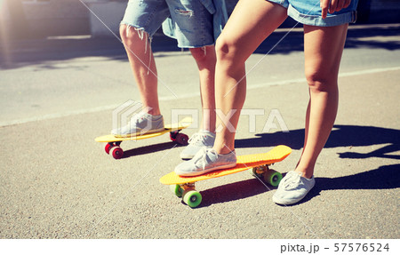 teenage couple riding skateboards on city street teenage couple riding skateboards on city street 57576524