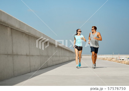 couple in sports clothes running outdoors 57576750