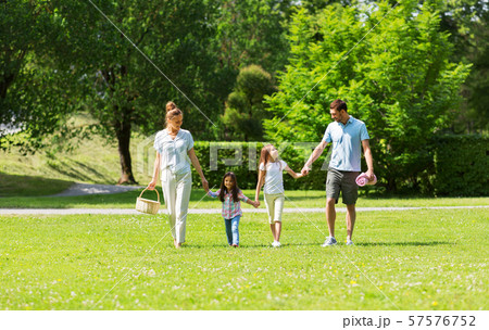 family with picnic basket walking in summer park 57576752
