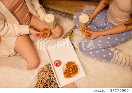 women drinking hot chocolate and eating waffles women drinking hot chocolate and eating waffles 57576909