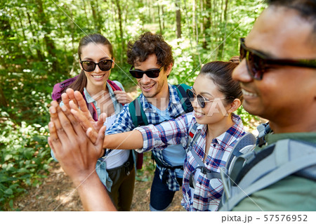 friends with backpacks hiking and making high five friends with backpacks hiking and making high five 57576952