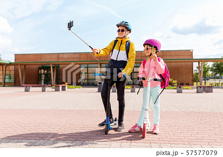 happy school kids with scooters taking selfie happy school kids with scooters taking selfie 57577079