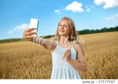 happy young girl taking selfie by smartphone 57577097