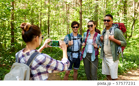 friends with backpacks being photographed on hike 57577231