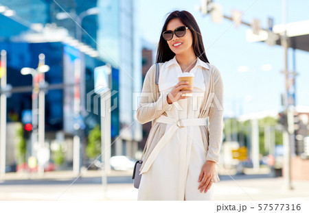 smiling woman with takeaway coffee cup in city smiling woman with takeaway coffee cup in city 57577316