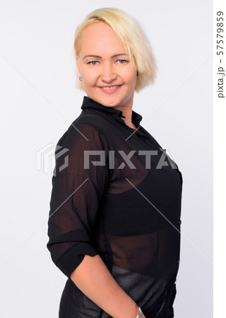Profile view of happy businesswoman with blond hair looking at camera Profile view of happy businesswoman with blond hair looking at camera 57579859