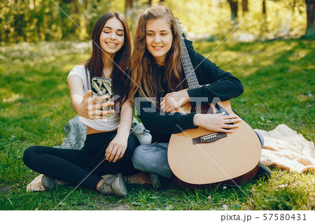Two girls with a guitar 57580431
