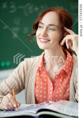 Smiling teacher feeling good while working at school Smiling teacher feeling good while working at school 57583690