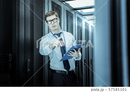 Elegant young man in eyeglasses working in the office Elegant young man in eyeglasses working in the office 57585101