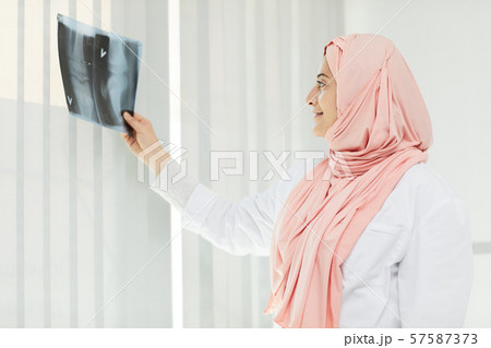 Middle-Eastern Female Doctor Holding X Ray Middle-Eastern Female Doctor Holding X Ray 57587373