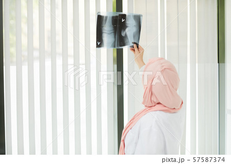 Middle-Eastern Female Doctor Looking at X Ray Middle-Eastern Female Doctor Looking at X Ray 57587374