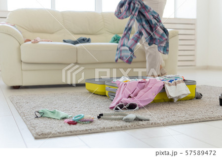 Vacation, travel and holidays concept - opening suitcase lying on the floor, top view Vacation, travel and holidays concept - opening suitcase lying on the floor, top view 57589472