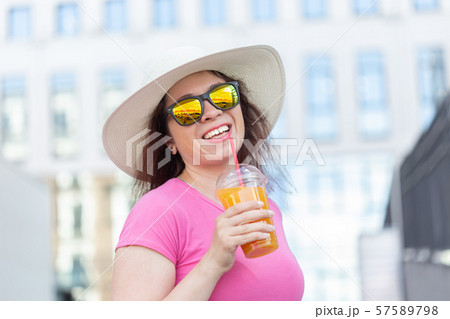 Close-up portrait of a beautiful stylish young woman in a hat and glasses walking around the city on Close-up portrait of a beautiful stylish young woman in a hat and glasses walking around the city on 57589798