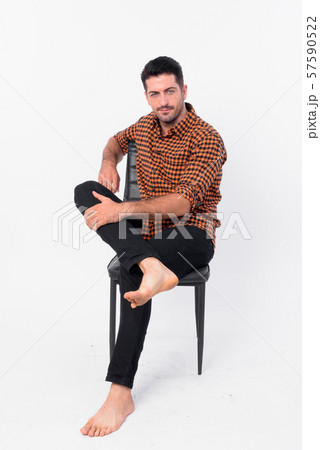 Full body shot of handsome bearded hipster man sitting on chair 57590522