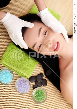 Woman under professional facial massage in beauty spa Woman under professional facial massage in beauty spa 57590523