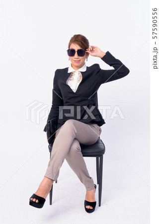Full body shot of mature Asian businesswoman sitting 57590556