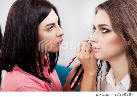 young, beautiful girl put on make-up in a beauty salon young, beautiful girl put on make-up in a beauty salon 57590587