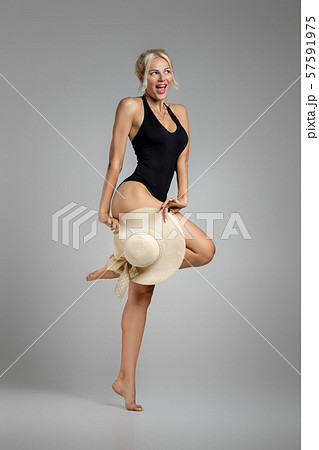 slim woman blonde in black bodysuit with straw hat 57591975