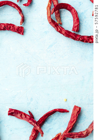 Dry red hot peppers on a blue background, forming a frame for copy space, top shot Dry red hot peppers on a blue background, forming a frame for copy space, top shot 57592781