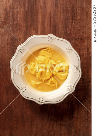 Italian tortellini with broth, shot from above on a dark rustic wooden background with copy space 57592807