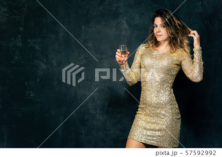 smiling lady in cocktail dress drinking champagne smiling lady in cocktail dress drinking champagne 57592992