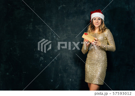 Happy woman with gift box and Santa Claus hat Happy woman with gift box and Santa Claus hat 57593012
