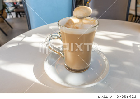 spoon of coffee latte macchiato foam in glass, spoon of coffee latte macchiato foam in glass, 57593413