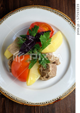 Boiled meat with a side dish and vegetables . restaurant menu 57593839