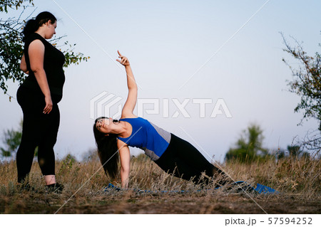 trainer teaching client doing yoga exercise trainer teaching client doing yoga exercise 57594252