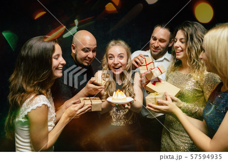 Friends congratulating young woman at her birthday Friends congratulating young woman at her birthday 57594935