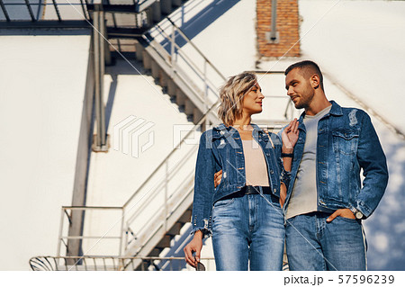 Young beautiful woman and man in jeans cloth posing on urban architecture 57596239