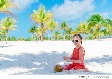 Little adorable girl with big coconut on the beach Little adorable girl with big coconut on the beach 57599958