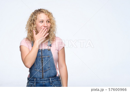 Surprised and amazed girl covered her mouth in surprise and looks aside. 57600966