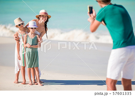 Family of four taking a selfie photo on their beach holidays. 57601335