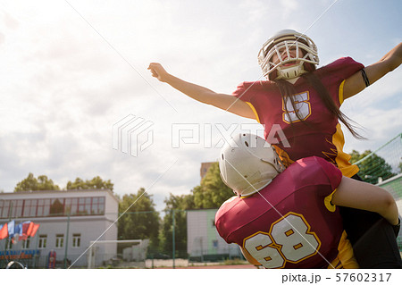 Image of two American football sportswoman wearing helmets with their hands to side against cloudy Image of two American football sportswoman wearing helmets with their hands to side against cloudy 57602317