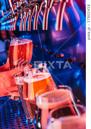 Hand of bartender pouring a large lager beer in tap 57602458